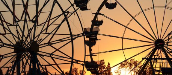 two ferris wheels silhouetted at sunset at the calfornia state fair in sacramento