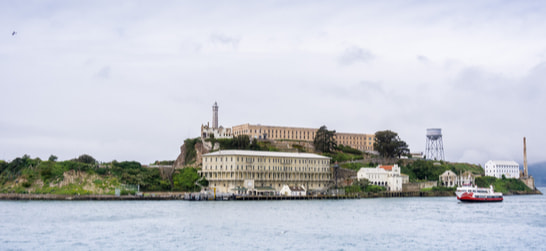 alcatraz island with ferries surrounding it 